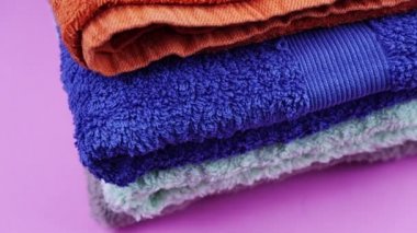 Kırmızı mavi ve gri havlular mor masanın üzerinde.