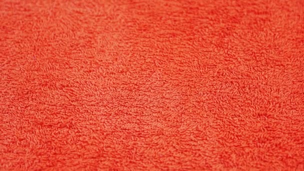 Miękki pomarańczowy ręcznik frotte kłamie i obraca się pod światło — Wideo stockowe