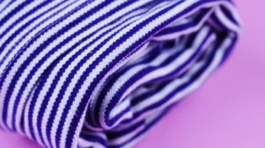 Masanın üzerinde mavi ve beyaz renkli çizgili pamuk kumaş var.