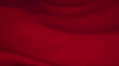 Kıvrımlı kırmızı pamuklu kumaş parlak elektrik ışığının altında yatıyor.