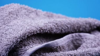 Mor renkli tüylü havlu yalan söylüyor ve dönüyor.