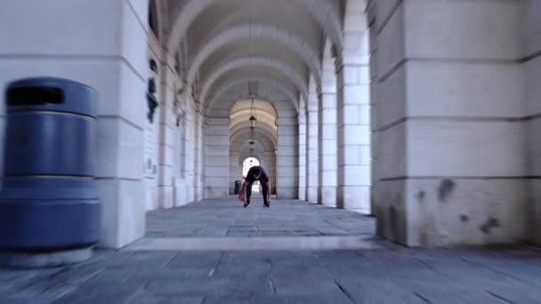 Un danseur professionnel exécute un ballet debout sous des arches — Video