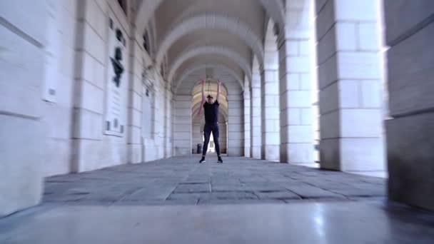 Активный человек исполняет современный балетный танец в историческом здании — стоковое видео