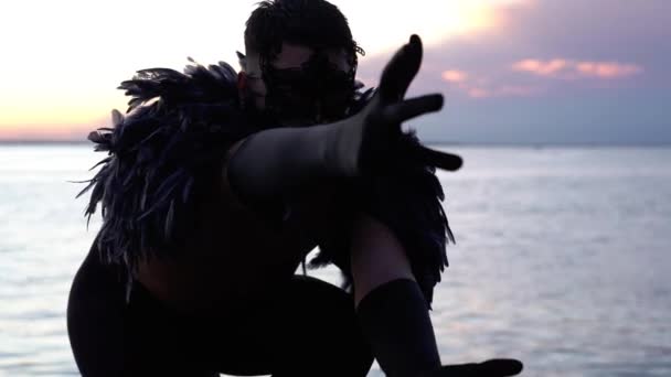 Umělec v černém opeřeném kostýmu s rukavicemi a krajkovou maskou — Stock video