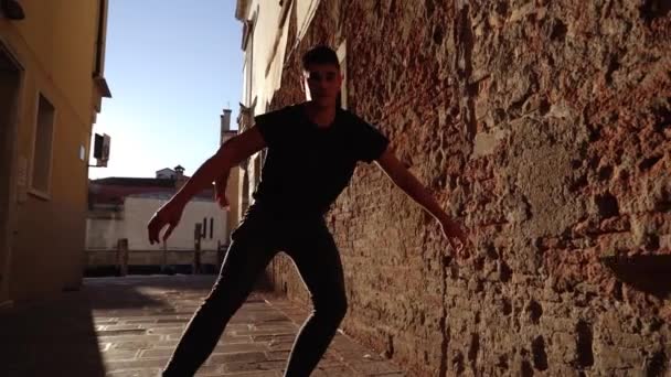 Choreograf tańczy balet między zabytkowymi ścianami budynku — Wideo stockowe