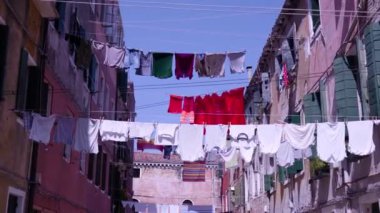 Temiz çamaşırlar kırmızı antik binalar arasındaki iplere asılı.