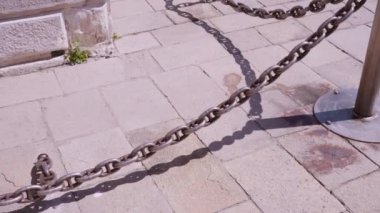 Şehrin eski beyaz binasının yanında çit gibi metal zincir