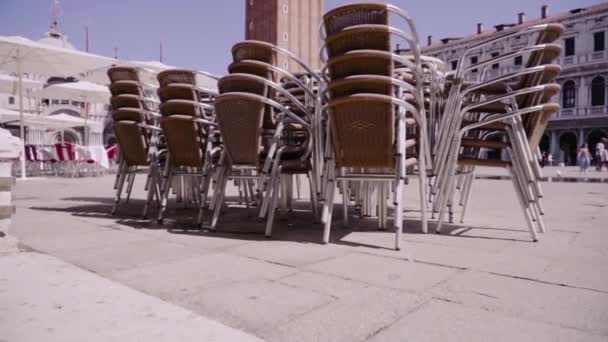 Stapelbare Sessel auf sonnigem Stadtplatz mit Rathaussturm — Stockvideo