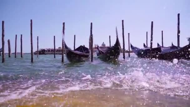 Vågor rullar på stenpiren medan tomma gondoler svingar på vatten — Stockvideo