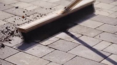 Kahverengi süpürge kaldırımdan siyah zemini siler