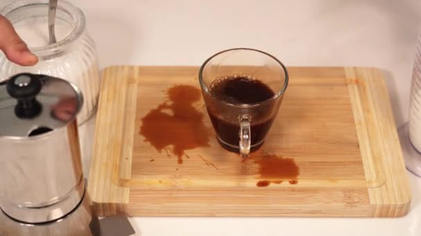 Muž nalévá kávu mléko do šálku a rozlévá na hnědé desce — Stock video