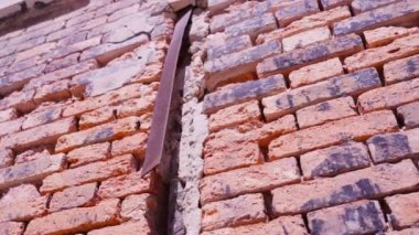 Metal kalas ve pencereli kırmızı tuğlalardan oluşan eski bina duvarı