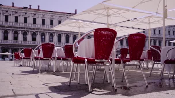 Cafetería con sombrillas en la plaza de la ciudad cerca del edificio antiguo — Vídeo de stock