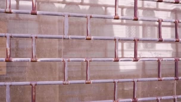 Іржавий паркан покритий старою фарбою проти мармурової будівлі — стокове відео