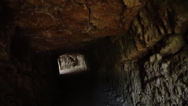 Tunel s kamennými zdmi a stropem se slunečním světlem na konci — Stock video