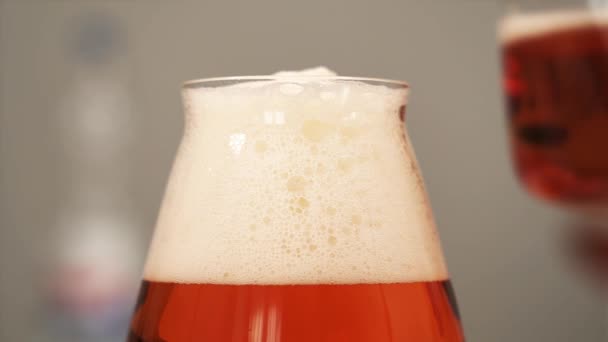 White foam of delicious orange beer on glass top closeup — Stock Video