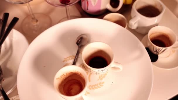 Tazas de café sucio de colores blanco y negro de pie sobre la mesa — Vídeo de stock