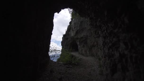 Dağ mağaralarının yanındaki dar yol bulutlu mavi gökyüzüne karşı. — Stok video