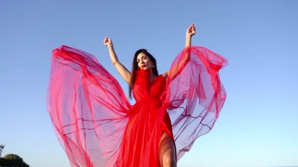 Wanita berambut panjang dengan gaun merah elegan dengan kereta lacy panjang — Stok Video