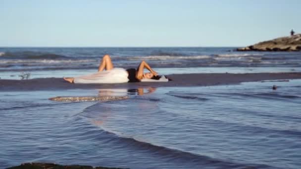 Giovane donna in gonna lunga bianca si trova sull'isola di sabbia bagnata — Video Stock