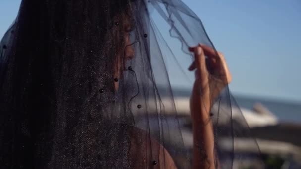 Leidenschaftliche Frau mit Ohrringen im schwarzen Schleier dreht Nahaufnahme — Stockvideo