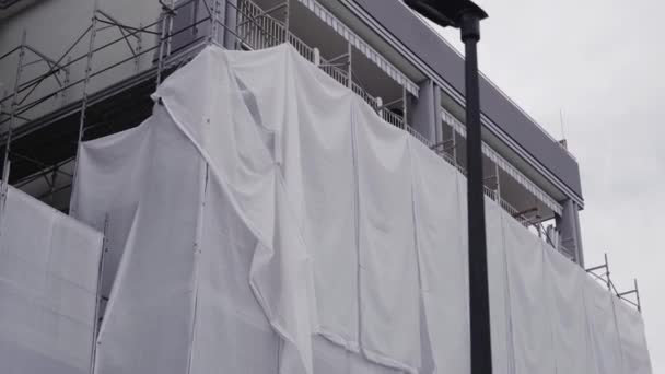 Lokale renovatie van een gebouw bedekt met witte stof — Stockvideo