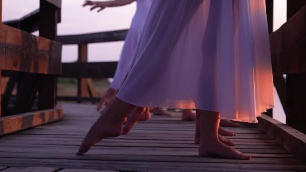 Frauen und Mann in Weiß stehen in Ballettpositionen auf Brücke — Stockvideo
