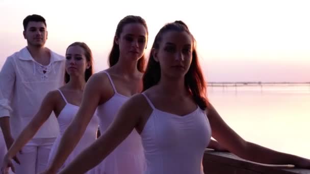 Mulheres e homens em exercícios de balé de dança branca na ponte — Vídeo de Stock