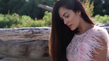 Tüylü şık bir esmer, yaşlı kütüğün yanında oturuyor.