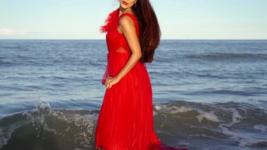 Uzun, gevşek saçlı genç kadın uçsuz bucaksız denizde duruyor.