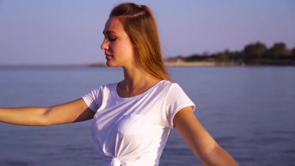 Frau in Weiß tanzt klassisches Ballett in ruhigem Wasser am Strand — Stockvideo