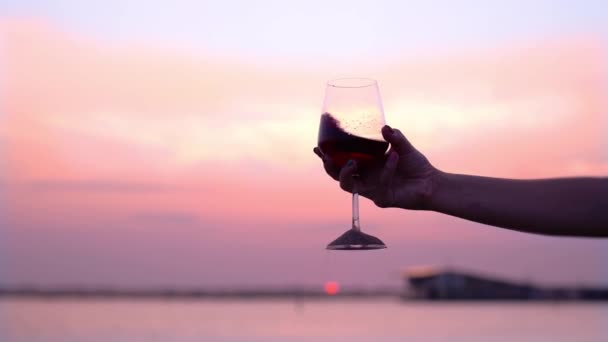 Kobieta trzęsie czerwonym winem w szklance usuwając piasek ze stopy — Wideo stockowe