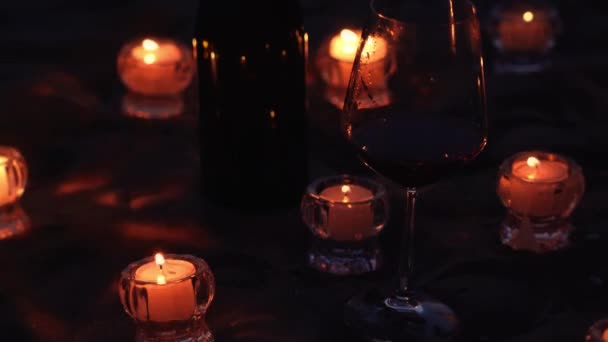 Vítr sfoukne hořící svíčky u sklenice na noční pláži — Stock video