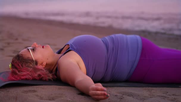 Mujer con sobrepeso descansa después de ejercicios deportivos en la playa — Vídeos de Stock