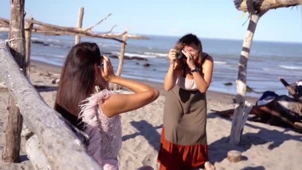Jovem em vestido longo captura modelo com câmera por mar — Vídeo de Stock