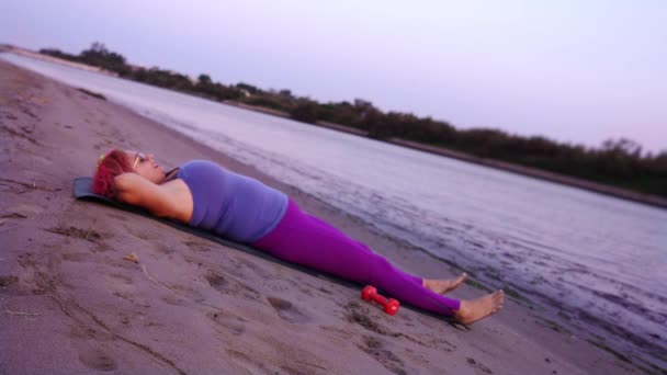 Η γυναίκα με το υπερβολικό βάρος κάνει κοιλιακούς κοιλιακούς στην παραλία — Αρχείο Βίντεο
