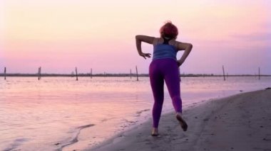 Aşırı kilolu kadın plajda spor egzersizleri yapmaya çalışıyor.