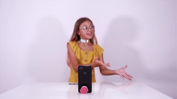 Tonåring flicka danser fotografering video på telefon nära bordet — Stockvideo