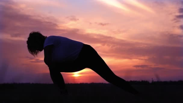 Mujer joven silueta ejercicios y estira la espalda y las piernas — Vídeos de Stock