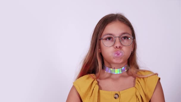 Genç kız baloncuğu beyaz yakın plan sakızla şişiriyor — Stok video