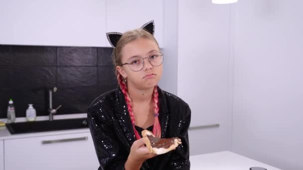 Menina perturbada com orelhas de gato come sanduíche com pasta de chocolate — Vídeo de Stock