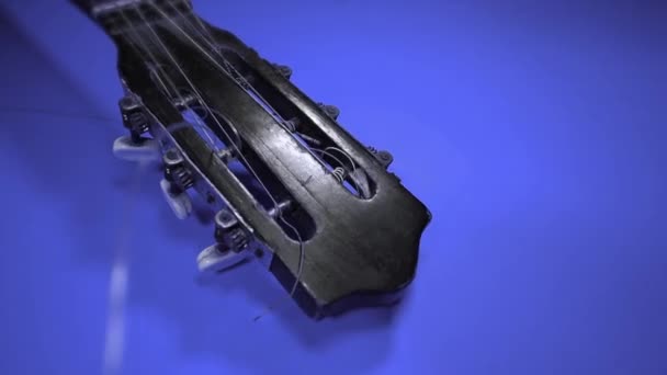Trä gitarr headstock mitt i skenet av färger — Stockvideo