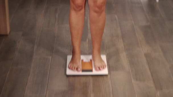 Plump woman with fair hair steps on scales and screams — Stock Video