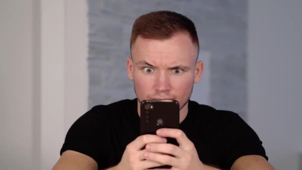 Gespierde buggy-eyed man types op de telefoon en wordt gek — Stockvideo