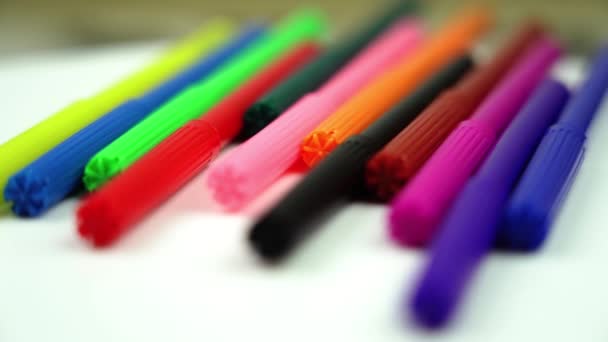 Движение мимо разноцветных маркеров лежащих на столе крупным планом — стоковое видео