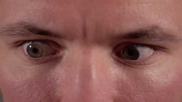 Эмоциональный человек с карими глазами и быстро двигающимися зрачками крупным планом — стоковое видео