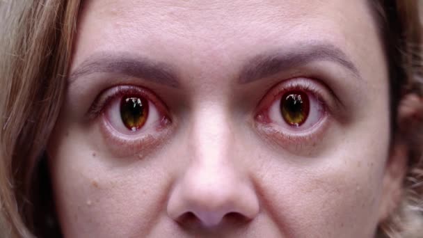 Женщина смотрит в камеру с огромными глазами меняет цвет на черный — стоковое видео