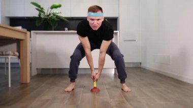 Sportif adam pompa tutuyor evde kahverengi ahşap zemin pompalıyor.
