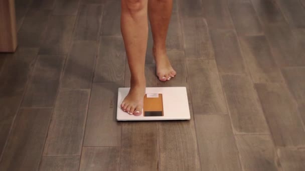 Надмірна вага блондинки в чорній білизні кроки на вагах крупним планом — стокове відео