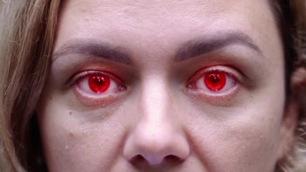 眼睛瞳孔闪烁着红绿光芒的可怕女人的脸 — 图库视频影像